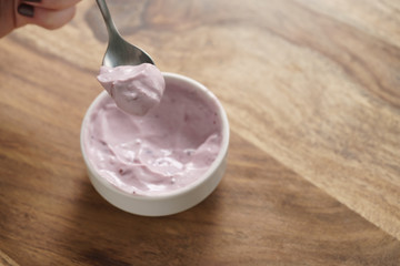 eating blueberry flavour yogurt with spoon