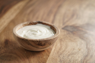 homemade organic yogurt in wooden bowl on table