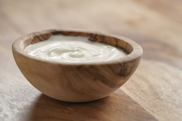 homemade organic yogurt in wooden bowl on table