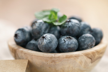 fresh blueberries in bowl on wood table with sack cloth