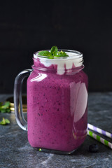 Detox drink - berry smoothie with yogurt, granola and honey on the stone, marble background