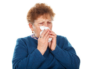 Elderly woman blowing her nose