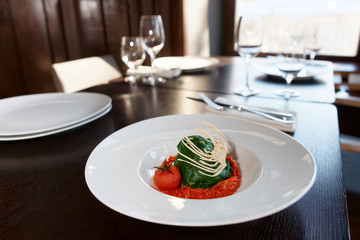 Stuffed spinach leaves with tomato sauce and cabbage