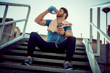 Thirsty athlete drinking water after workout