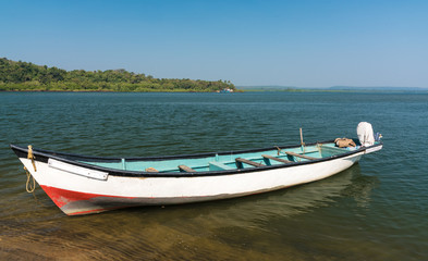 the river, the boat at the coast, the blue sky, the horizon