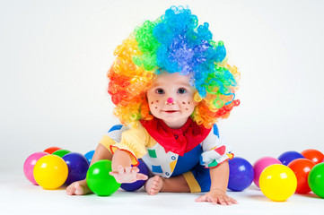 Fototapeta na wymiar Child clown with a red nose multicolored wig in with balls