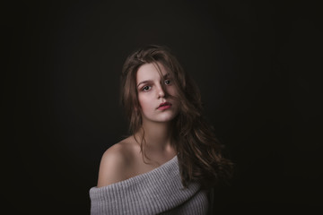 Naklejka premium Tender young woman with naked shoulders in the dark
