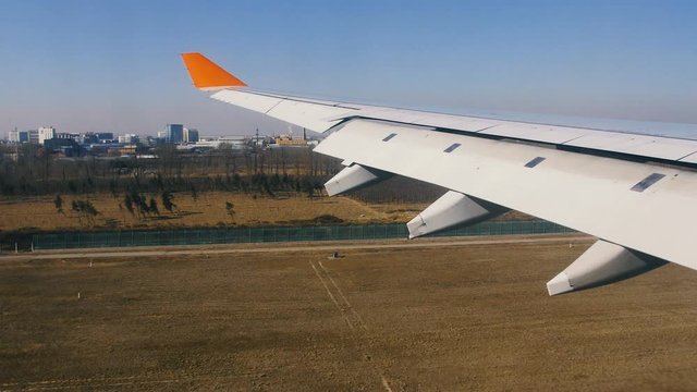 Airplane landing at airport, view of the wing from inside