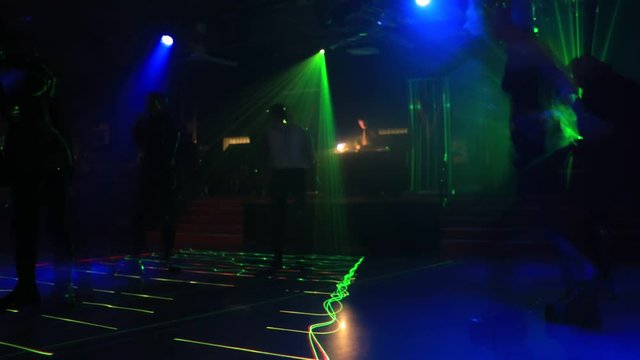 Timelapse of people dancing in disco dance floor background of a disco club with violet, blue and pink strobe lights. Entertainment, leisure and nightlife concept. Adult lifestyle.