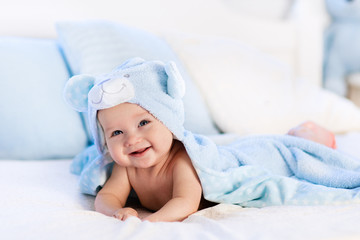 Fototapeta na wymiar Baby in towel after bath in bed