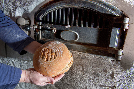 handgemachtes Bauernbrot in H&auml;nden ausgebacken vor Holzbackofen