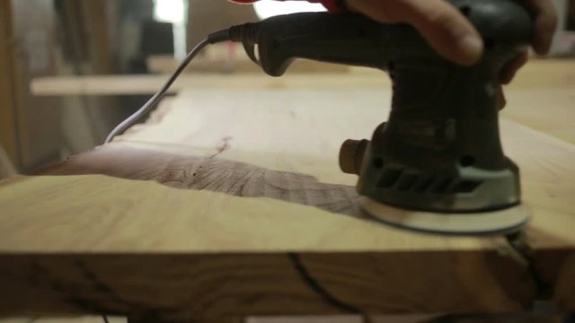 Carpenter grinds board grinding machine. close-up