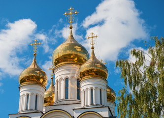 Fototapeta na wymiar Golden domes and crosses of an orthodox temple against the sky