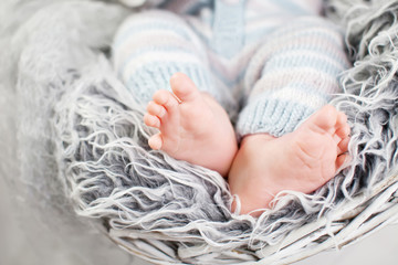 Close up picture of new born baby feet in knitted plaid