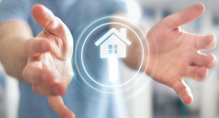 Businessman holding 3D rendering icon house in his hand