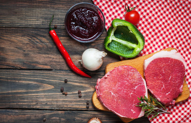 Fresh raw beef steak and pepper on wood