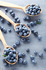 Ripe and tasty blueberries on grey wooden table