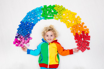 Child playing with rainbow plastic blocks toy