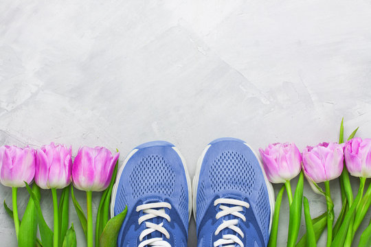 Spring flatlay sports composition with blue sneakers and purple tulips.