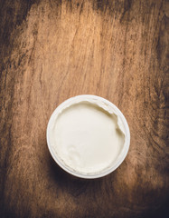 Yogurt  in plastic cup  on rustic wooden background, top view