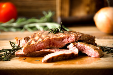 rare steak rosemary rectangular wooden cutting board pepper