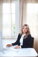 Beautiful business women at her personal office working on her desk.