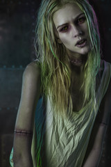 Blonde zombie woman on dark background