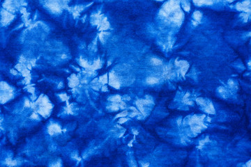 Fototapeta na wymiar Pattern of blue tie batik dye on cotton cloth, Dyed indigo fabric background and textured, Painted blue watercolor on white cotton cloth