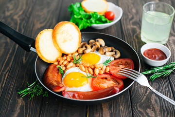 Breakfast tomatoes, sausages, beans, mushrooms, eggs,toast and herbs 