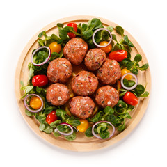 Raw meatballs on cutting board on white background