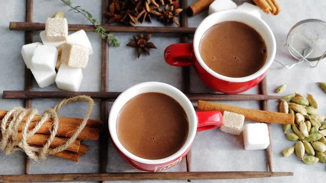Hot sweet cocoa chocolate drink in cups with spices and suger. Top view. 