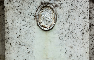 Old gravestone with damaged portrait of the buried person