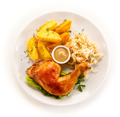 Grilled chicken leg with chips and vegetables on white background 