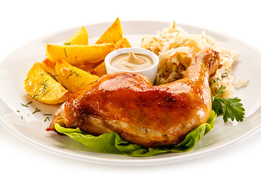 Grilled chicken leg with chips and vegetables on white background 