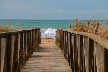 Wooden path to the beach and to the bottom of the waves
