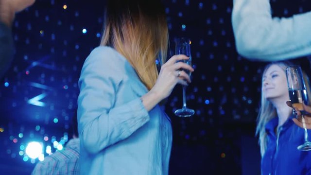 Young caucasian woman dancing in a nightclub with Ocala wine in hand. Club vacation, have a good time with friends