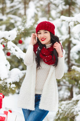 Pretty woman talking on cell phone or mobile. Beautiful woman in the woods in the winter time smiling