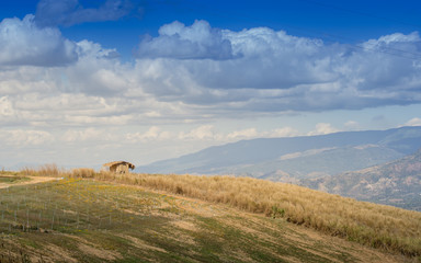 Obraz premium bamboo hut on the hills, meadows with his sky and clouds.