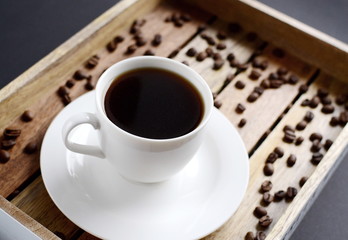 White cup of coffee on the wooden tray