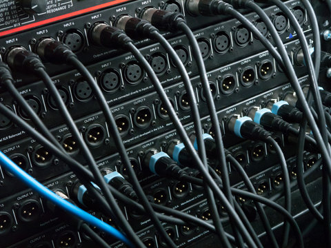 XLR cables plugged into different inputs and outputs at a recording studio