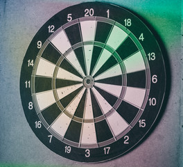 Vintage dart board on dark wall