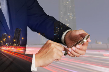 Double exposure of businessman use smartphone, light trails on the street and urban at dusk, night as business, Technology, telecommunication and Communication concept.