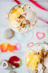 Ice cream dessert on table with hearts, ribbons and cloves.