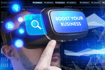 Business, Technology, Internet and network concept. Young businessman working in virtual reality glasses sees the inscription: Boost your business