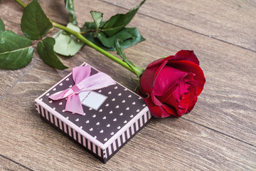 Rose  and gift box on a wooden background. Valentines Day background
