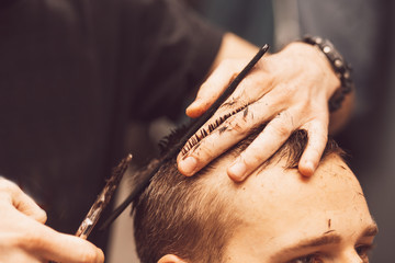 Obraz na płótnie Canvas Hairdresser makes hairstyle a man with a beard