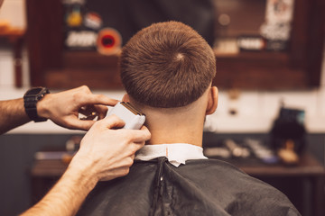 Hairdresser makes hairstyle a man with a beard