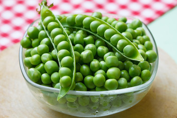 Fresh green pea in bowl on wooden background