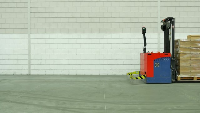 Forked Automatic Guided Vehicles (AGV) pallet truck, unmanned driving through factory hall