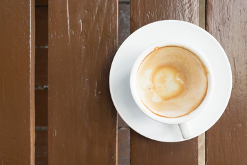 Coffee stains on a cup of cappuccino coffee on wooden table.